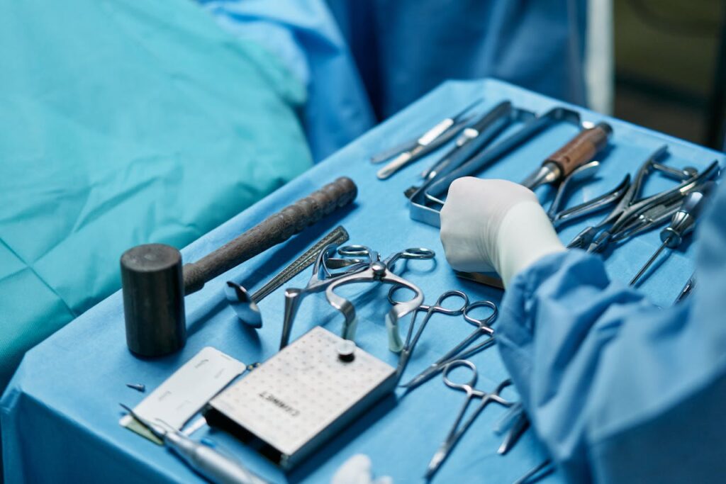 Close-up of surgical tools and surgeon's hands in an operating room setup.
