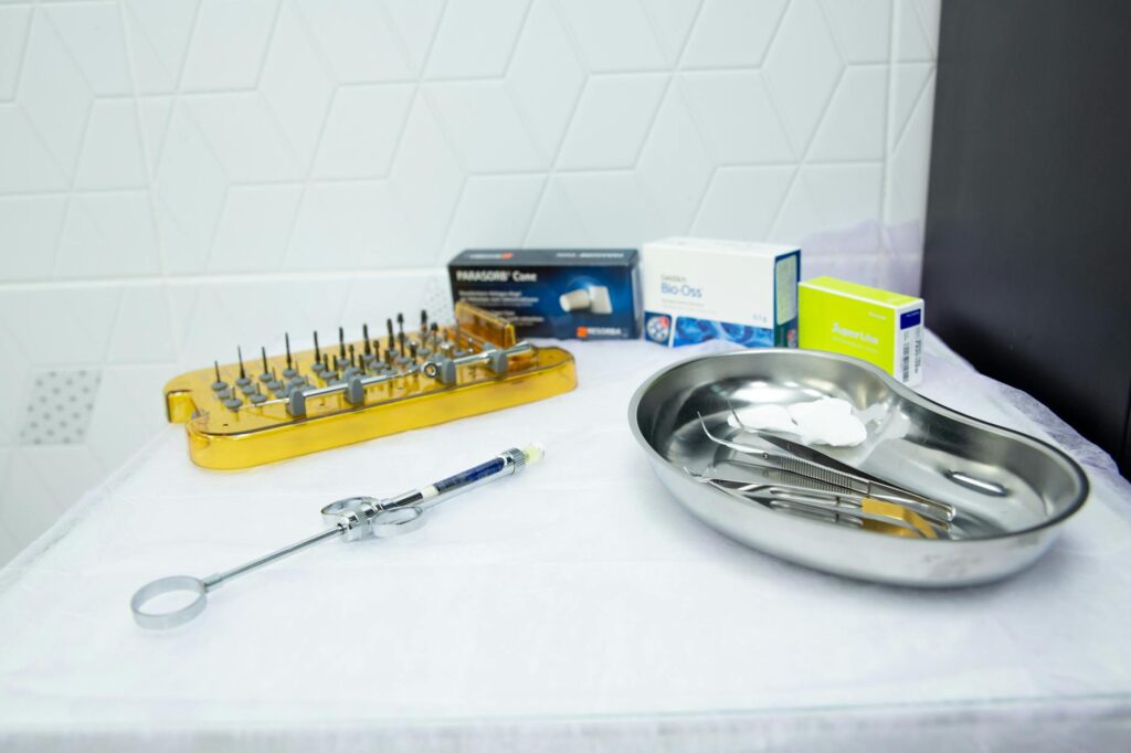 A set of sterile medical instruments and boxes on a table in a clinical setting.